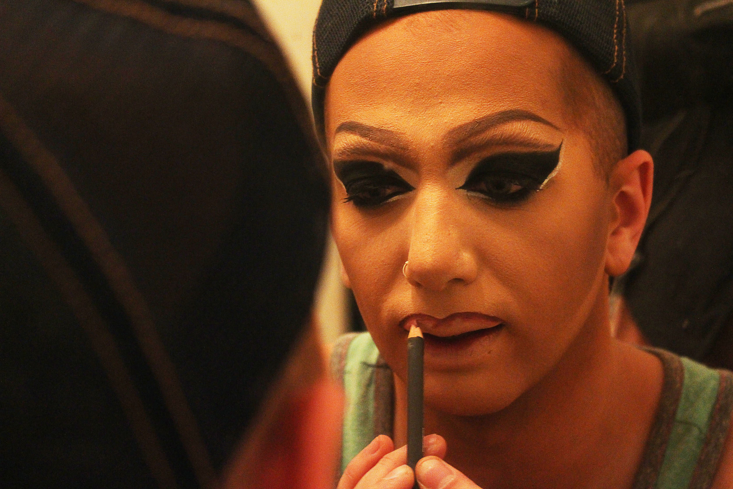 Matty Cameron applying makeup in the mirror.