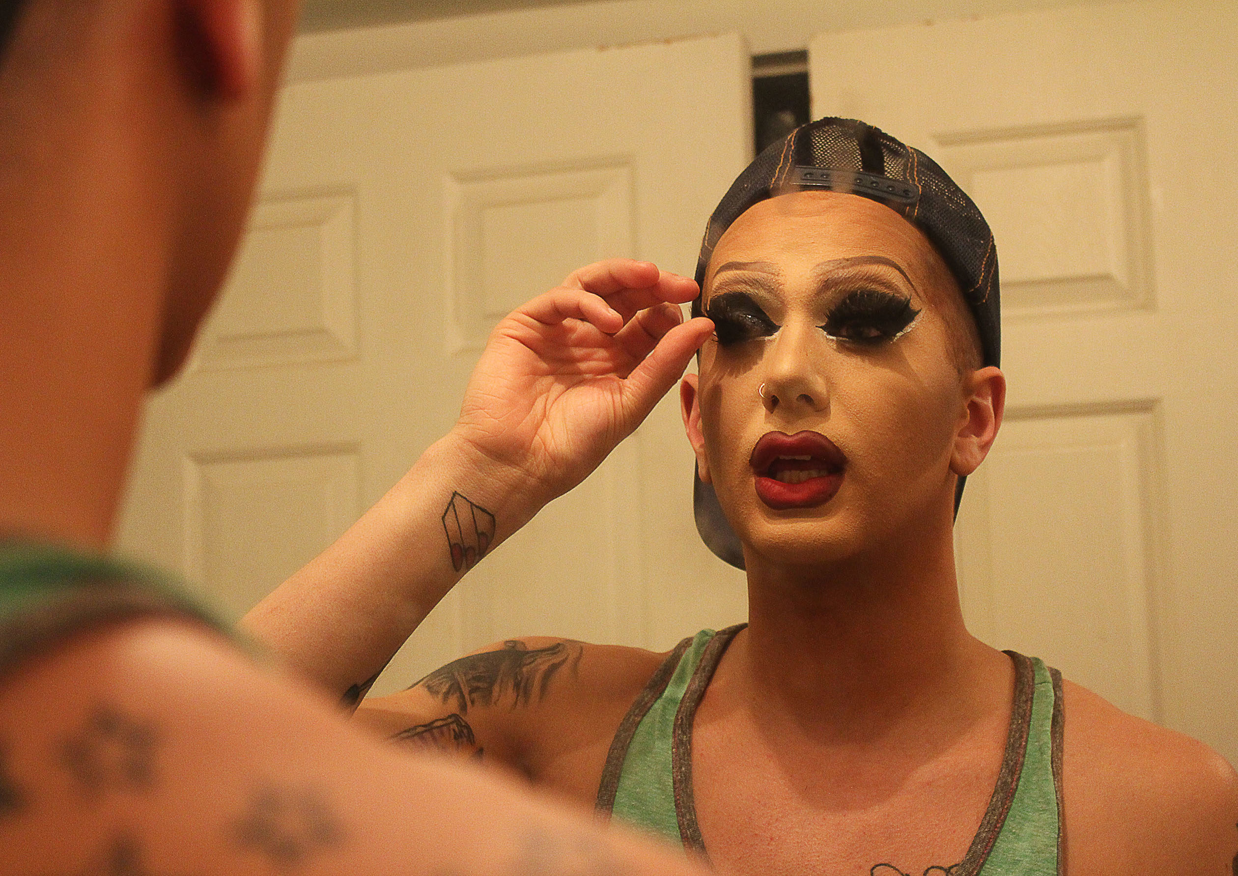 Matty Cameron applying makeup in the mirror.
