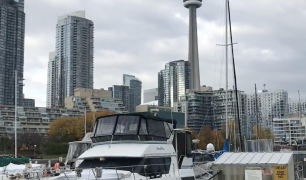 A photo of a boat docked, with Toronto and the CN Tower in the background.